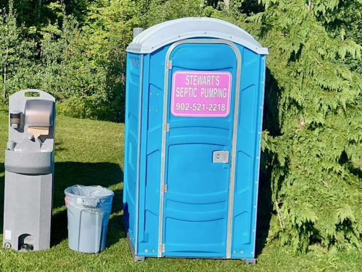 Stewart's standard blue portable toilet beside a hand wash station
